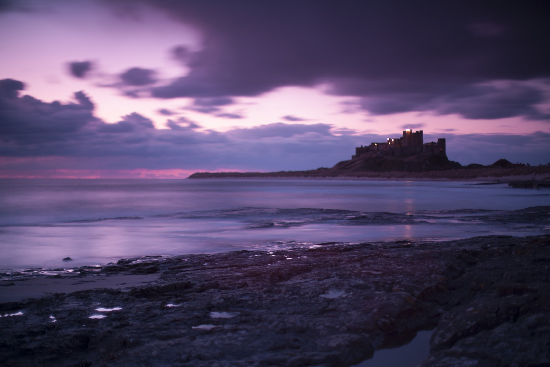 großbritannien england schloss bamburg meer küste abend lila himmel wolken schloss ufer flieder lila wolken landschaft