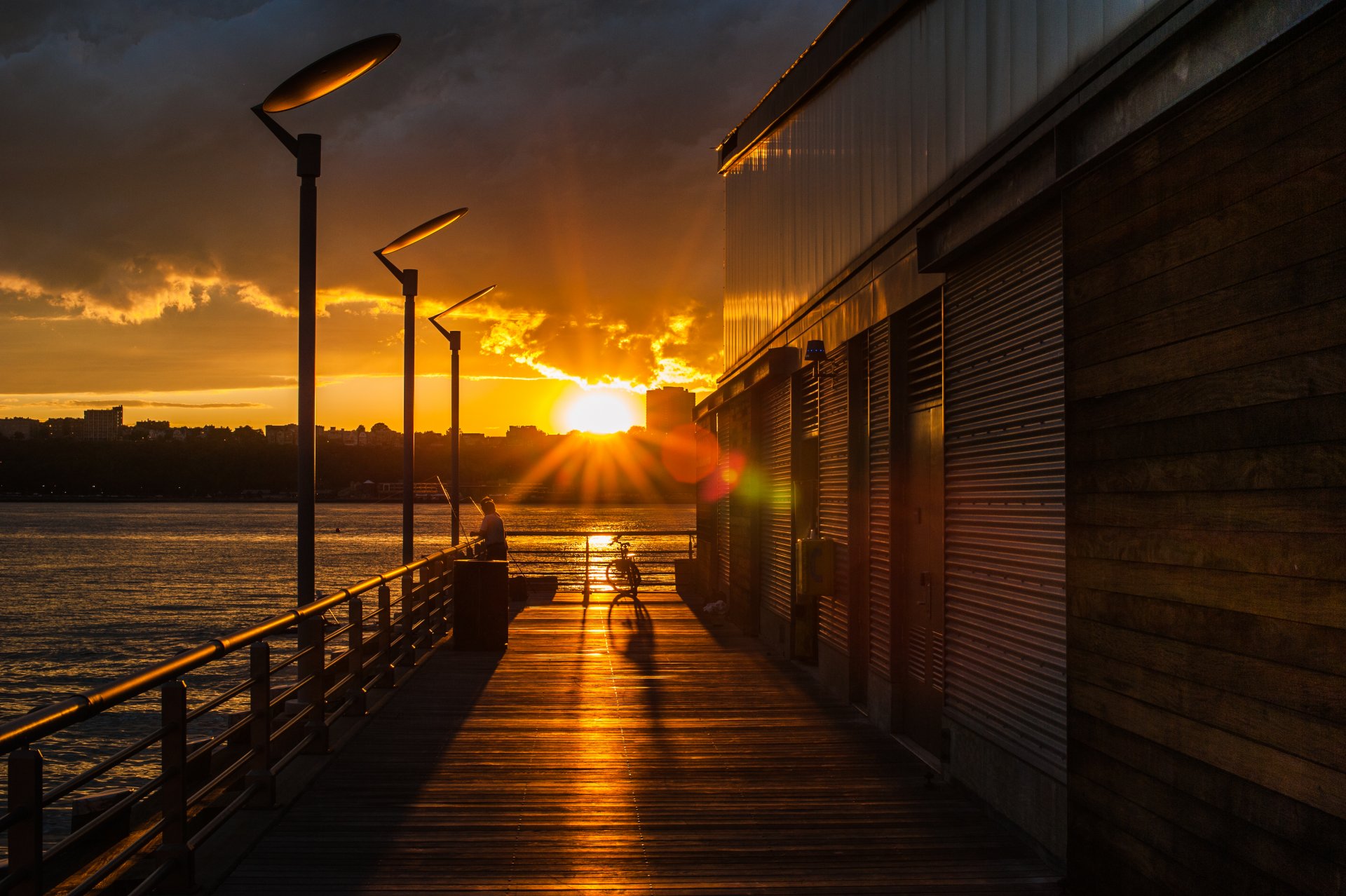 città sera tramonto sole cielo nuvole alberi mare lago acqua lampade bicicletta