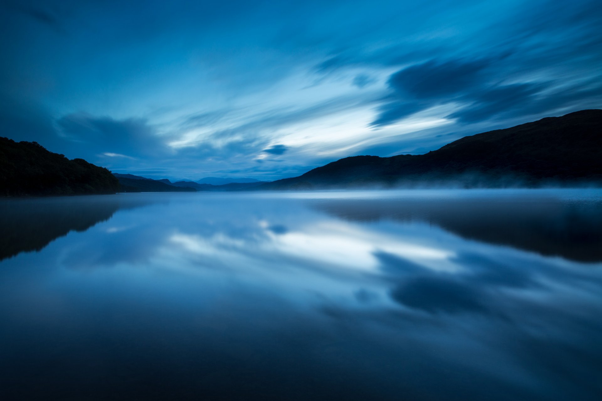 großbritannien england naturschutzgebiet see abend wasser glatte oberfläche nebel dunst blau himmel wolken reflexion