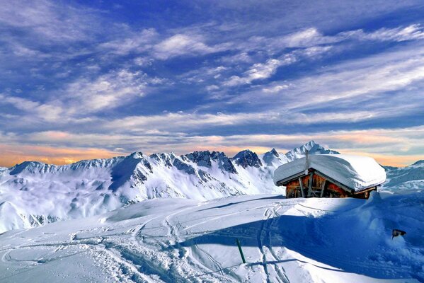 A house in the snow on the background of clouds