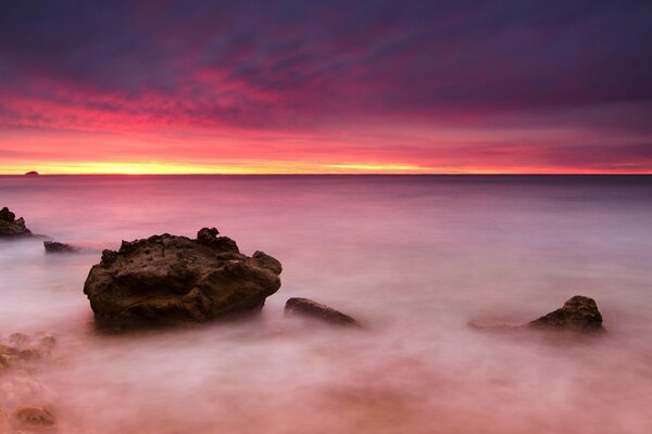 Rocks on the sea. Pink sky