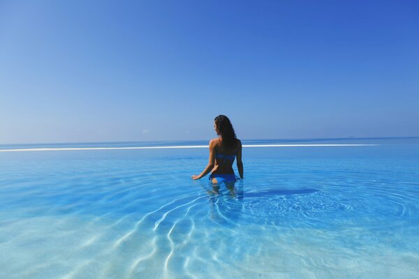 Fille en maillot de bain bleu debout dans l eau