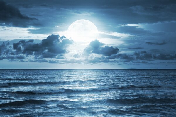 Una bella luna piena tra le nuvole crea un incantevole paesaggio notturno