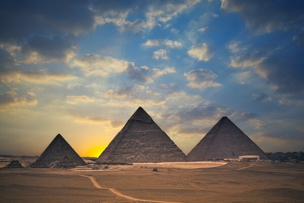 Deserto, piramidi e tramonto nel cielo