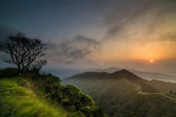 Aube dans les montagnes dans le brouillard et les nuages