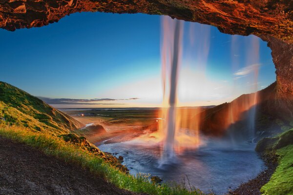 Wodospad Seljalandsfoss w promieniach słońca na terytorium Islandii