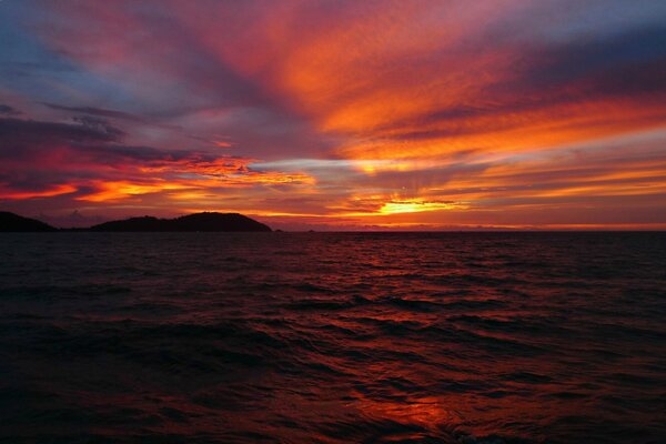 Das Meer auf dem Hintergrund des roten Sonnenuntergangs