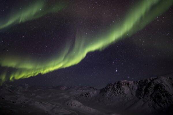 Northern lights in the mountains. A green miracle in the sky