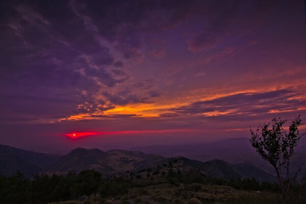 Tramonto crepuscolare sullo sfondo delle montagne