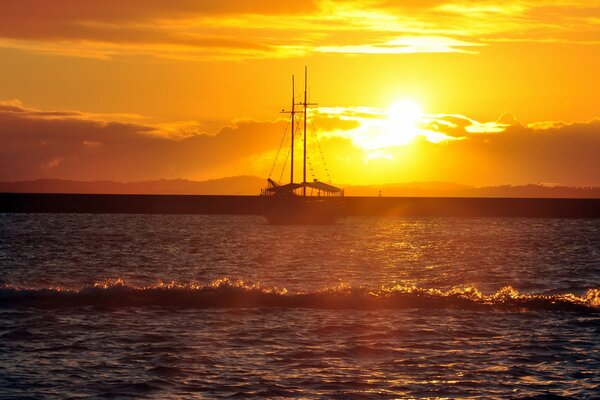 Silhouette of a ship at sea at sunset