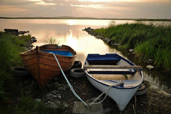 Boat on the shore of the lake at sunset