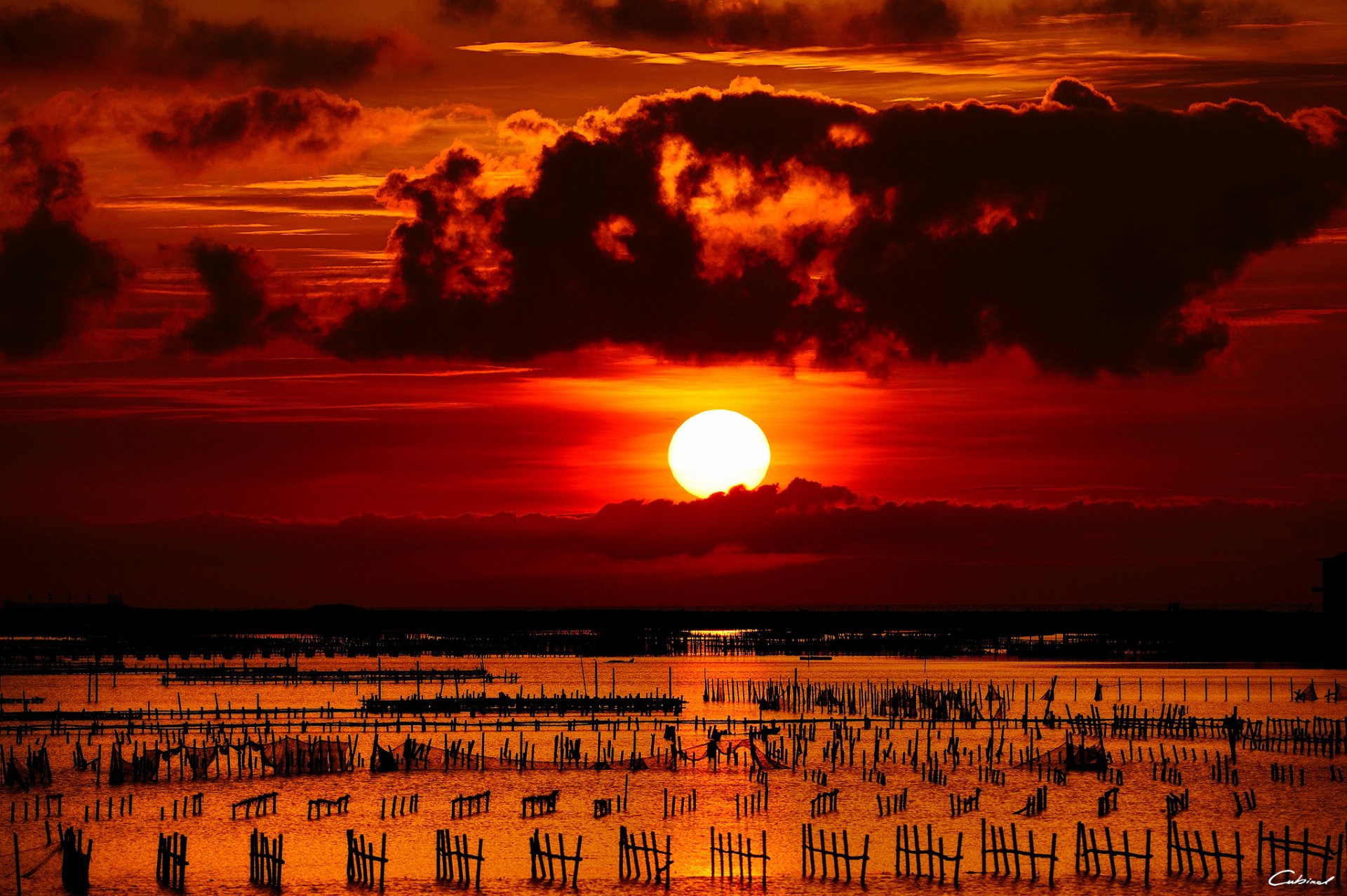 puesta de sol mar sol bolardos valla redes nubes contsrast