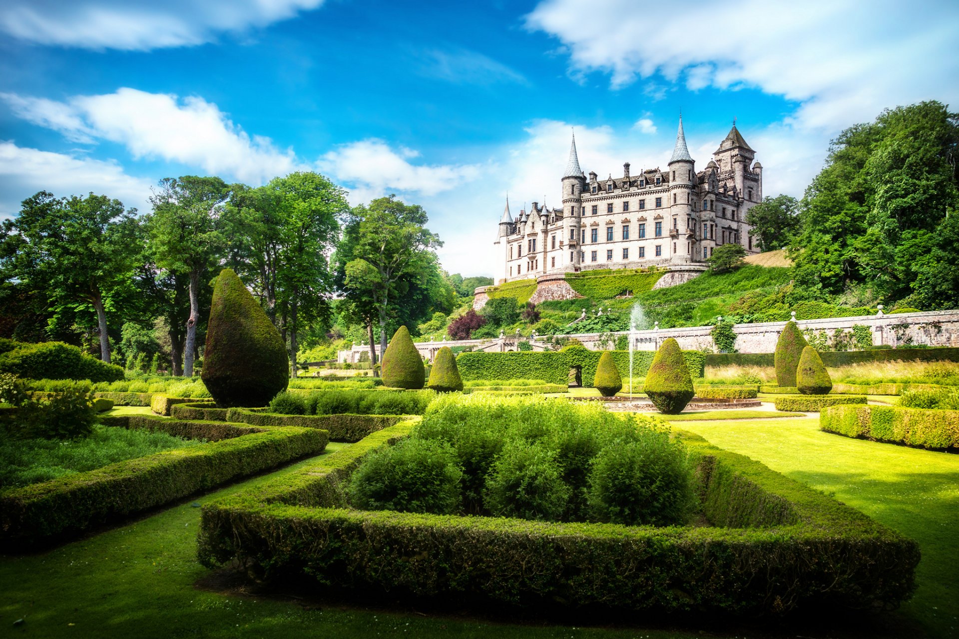 dunrobin zamek sutherland szkocja alba wielka brytania zamek park słońce światło niebo chmury zieleń trawa trawnik krzewy drzewa fontanna natura krajobraz