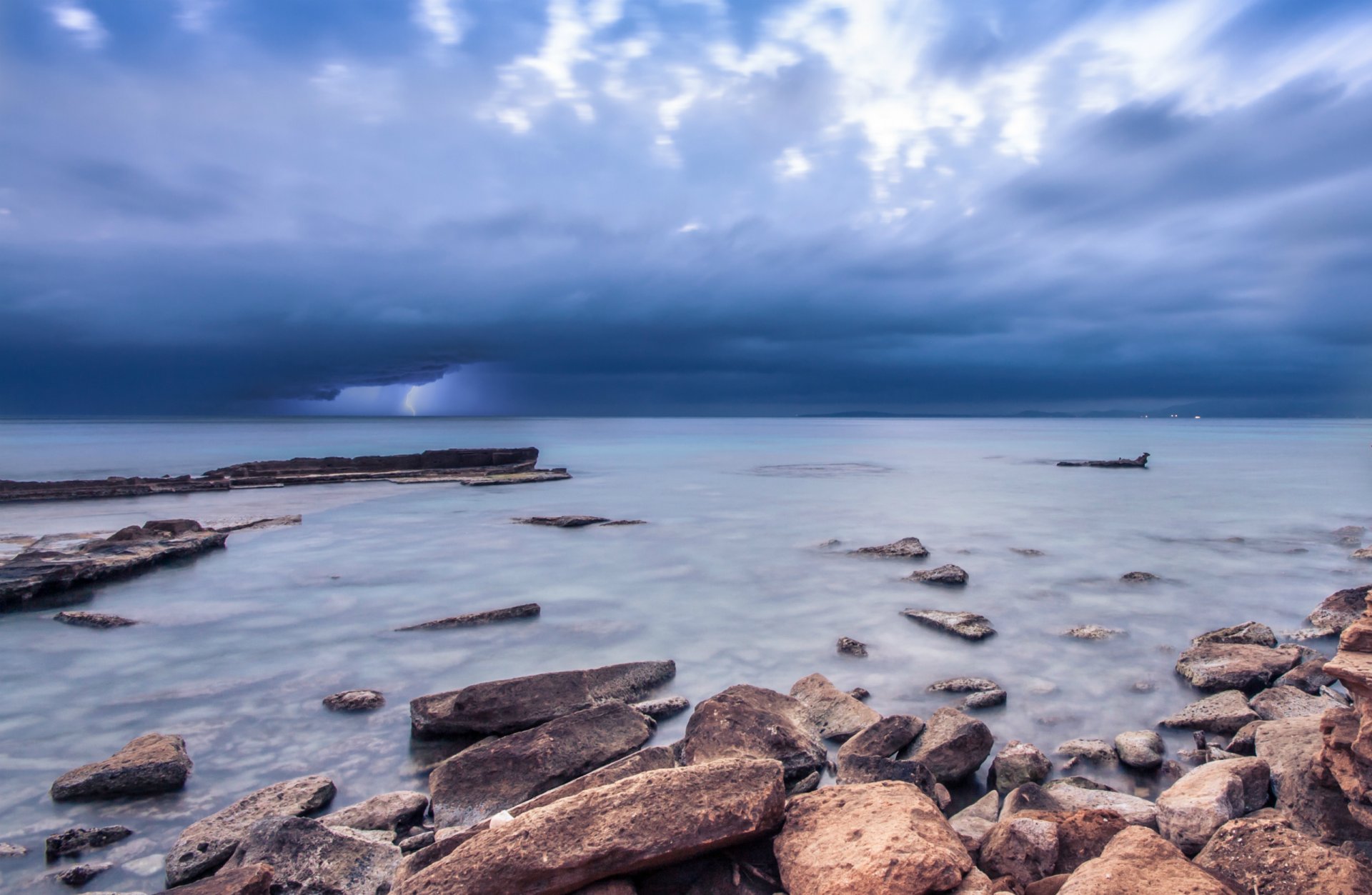 morze ocean brzeg kamienie błękit niebo chmury burza błyskawica