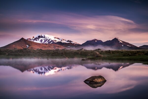 Montañas nocturnas de Islandia que se reflejan en el lago