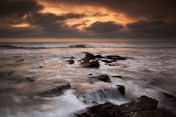 The ocean water is beating against the rocks