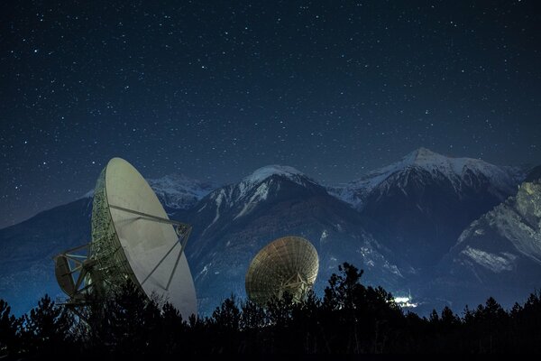 Satellite dishes at night in the mountains