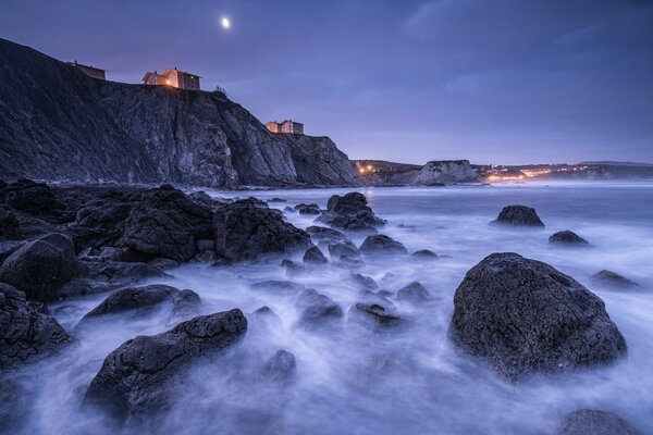 The coast of the Bay of Biscay in Spain at night among the moon