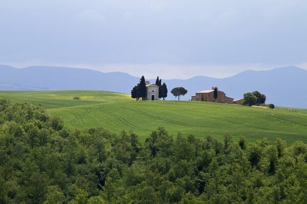 Gebäude mitten auf einem Feld in der Toskana