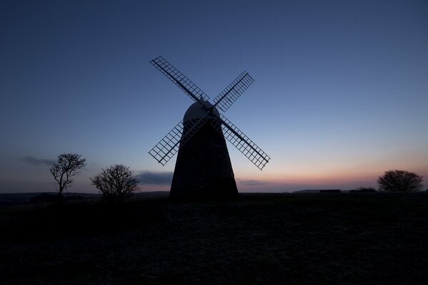 Eine Mühle auf einem Feld bei Nacht