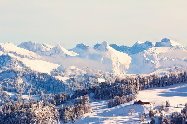 Casa innevata tra boschi e montagne