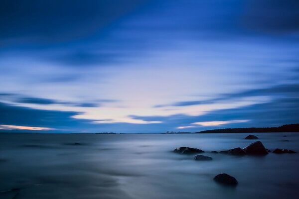 Dense fog over the water and blue sky evening