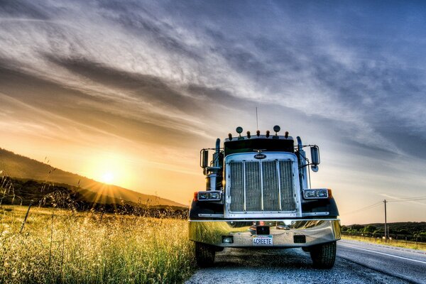 Truck on the side of the field during sunset