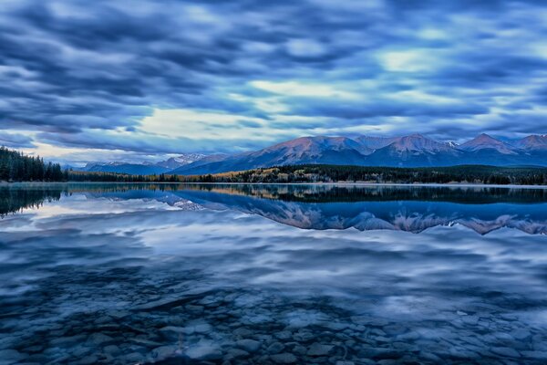 Reflexion von Bergen und Wolken im See