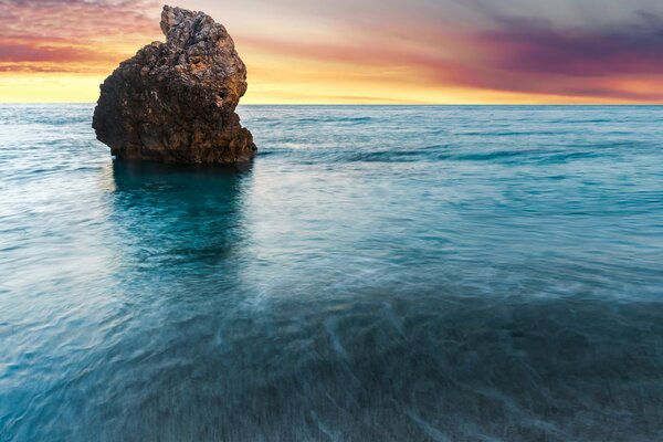 Alba su una roccia solitaria nell oceano