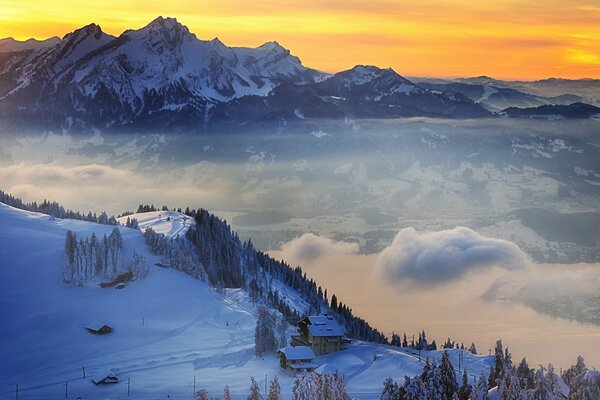 Schweizer Berge im Schnee und Wolken unter ihnen