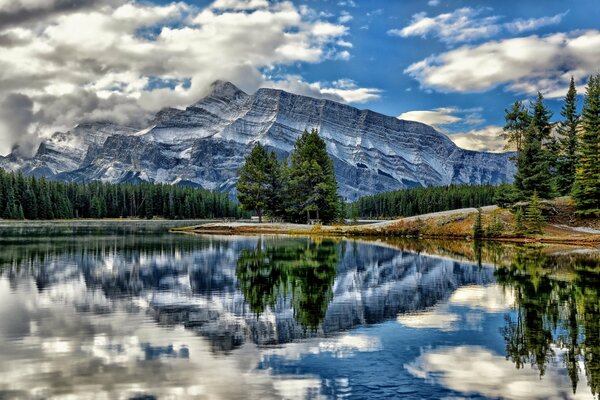 Канада, национальный парк банф, отражение гор и деревьев в озере вермилион
