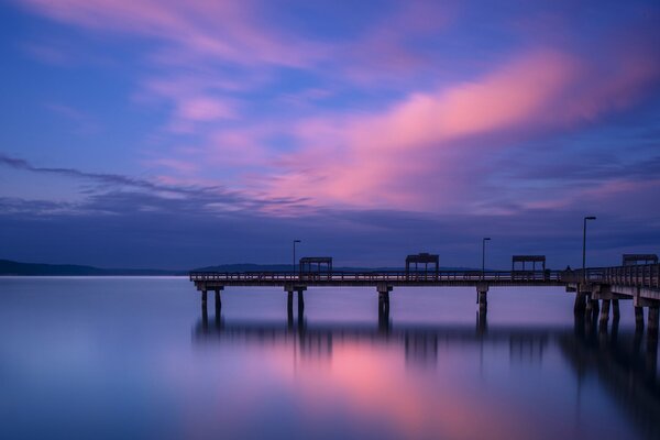 A lonely pier on the background of sunset