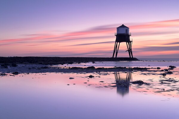 Lighthouse in the UK on the seashore at dawn