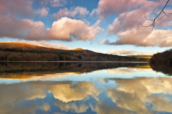 Reflejo de nubes y colinas en el lago