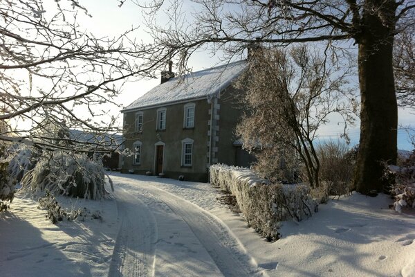 Winter landscape with a house by the road