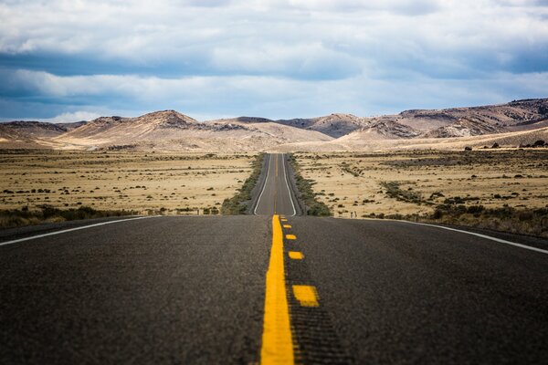 A road with a yellow stripe in the Nevada desert