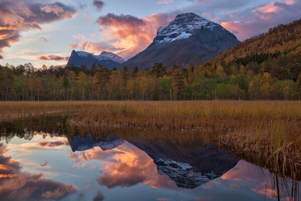 Pink clouds are reflected in the lake