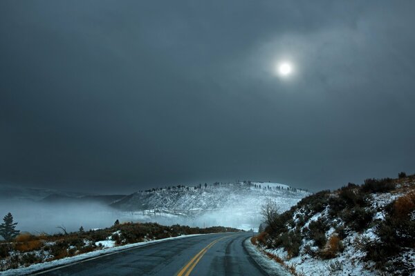 Camino de invierno desierto bajo la Luna fría