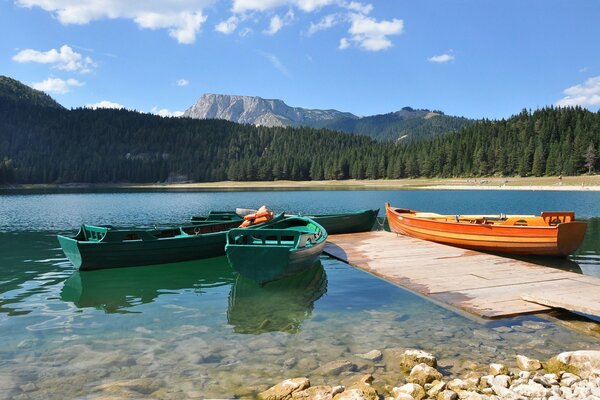 Несколько лодок на черном озере в Черногории