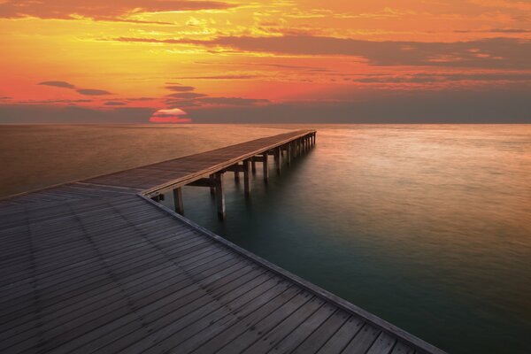 Schöne Meereslandschaft mit Pier und untergehender Sonne