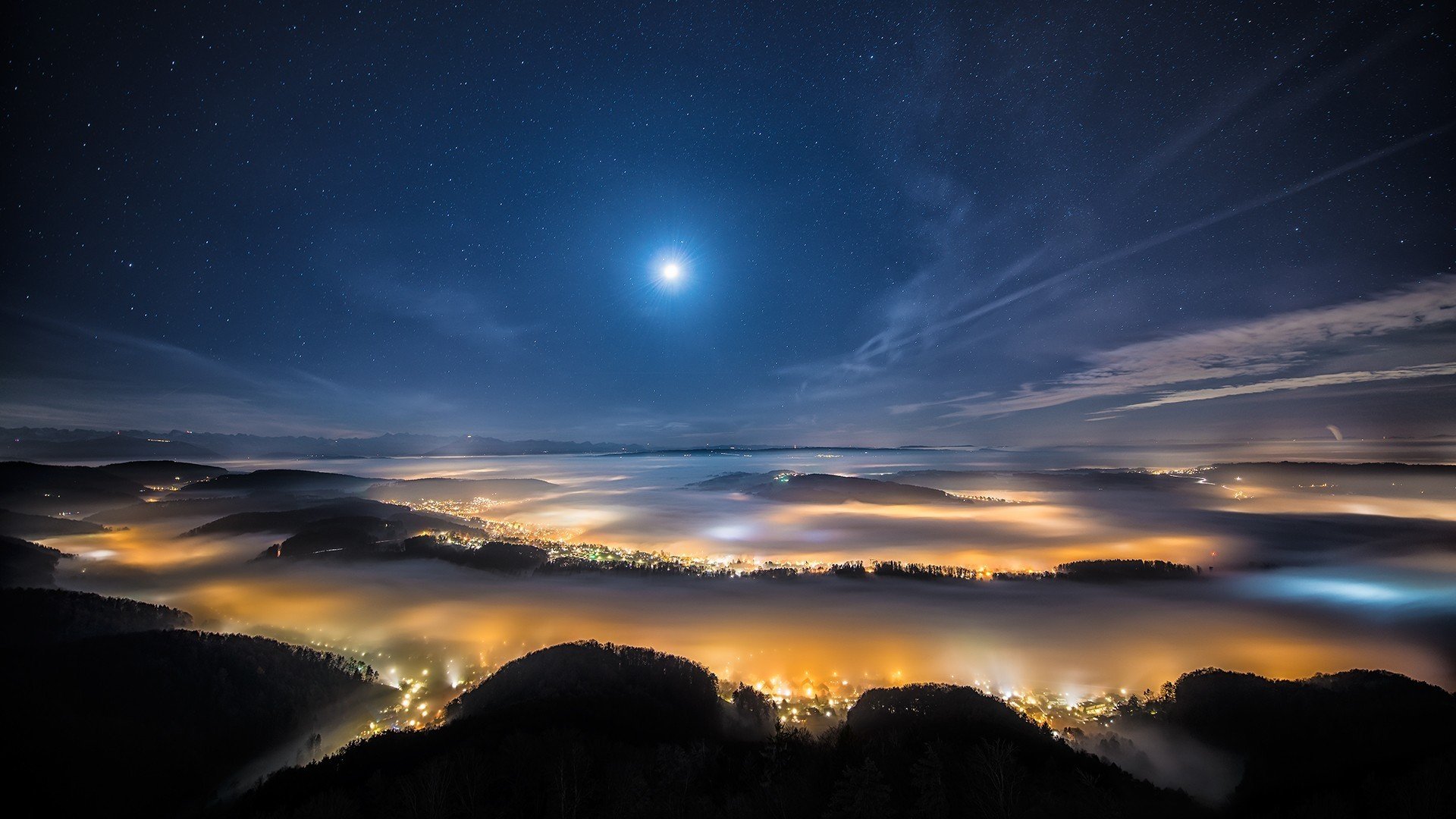 nuit ciel étoiles. lune collines brouillard ville lumières