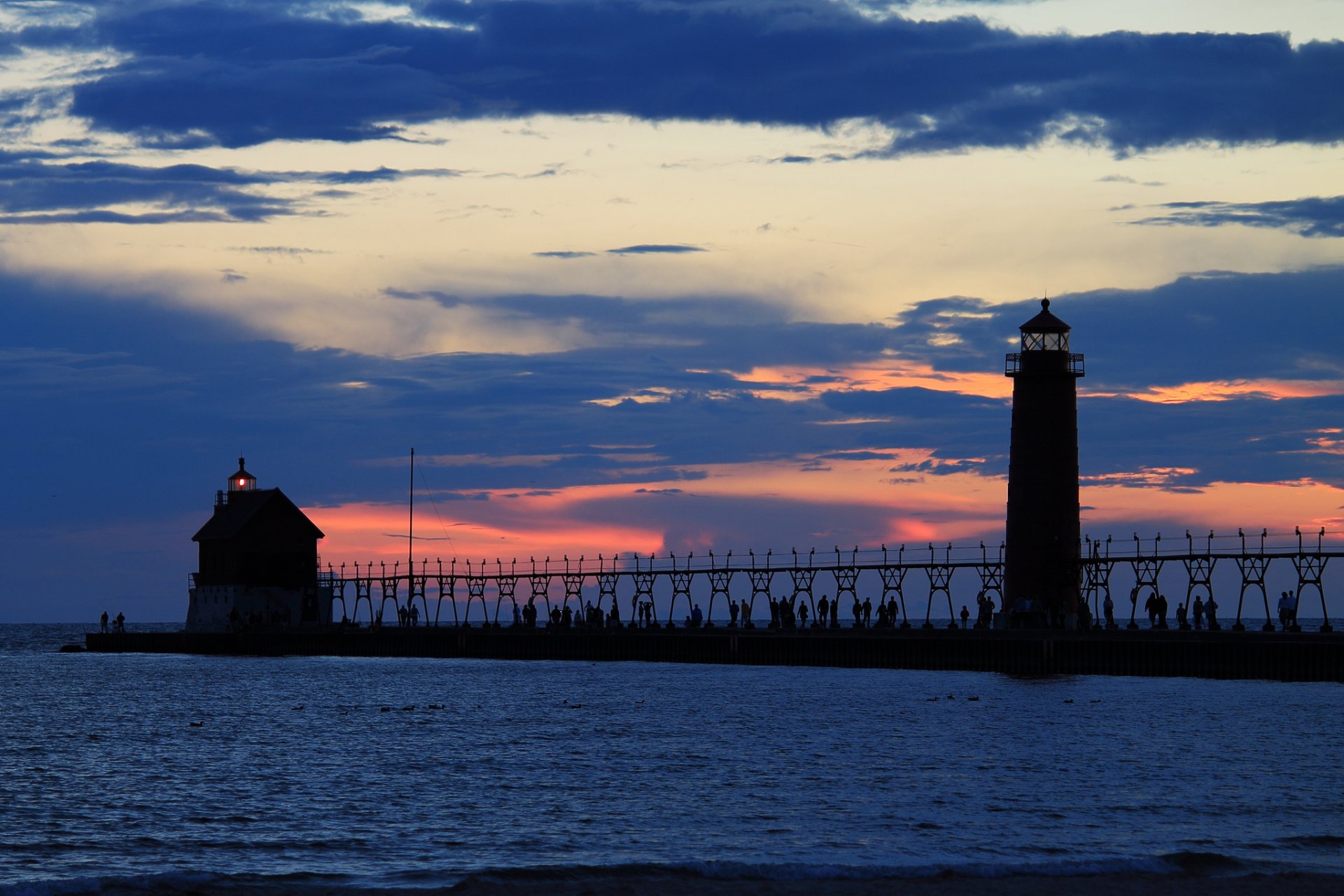 soir coucher de soleil orange ciel nuages mer phare lumière quai jetée gens