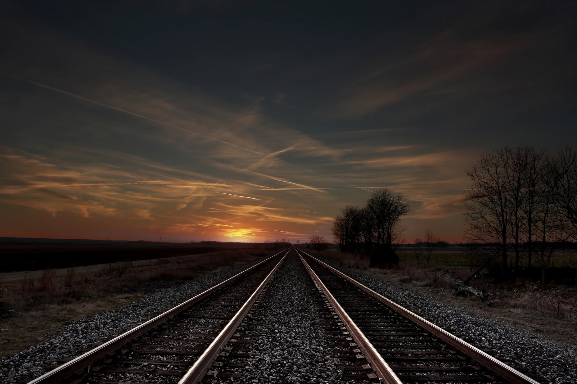 ferrocarril rieles árboles campo tarde puesta del sol cielo nubes