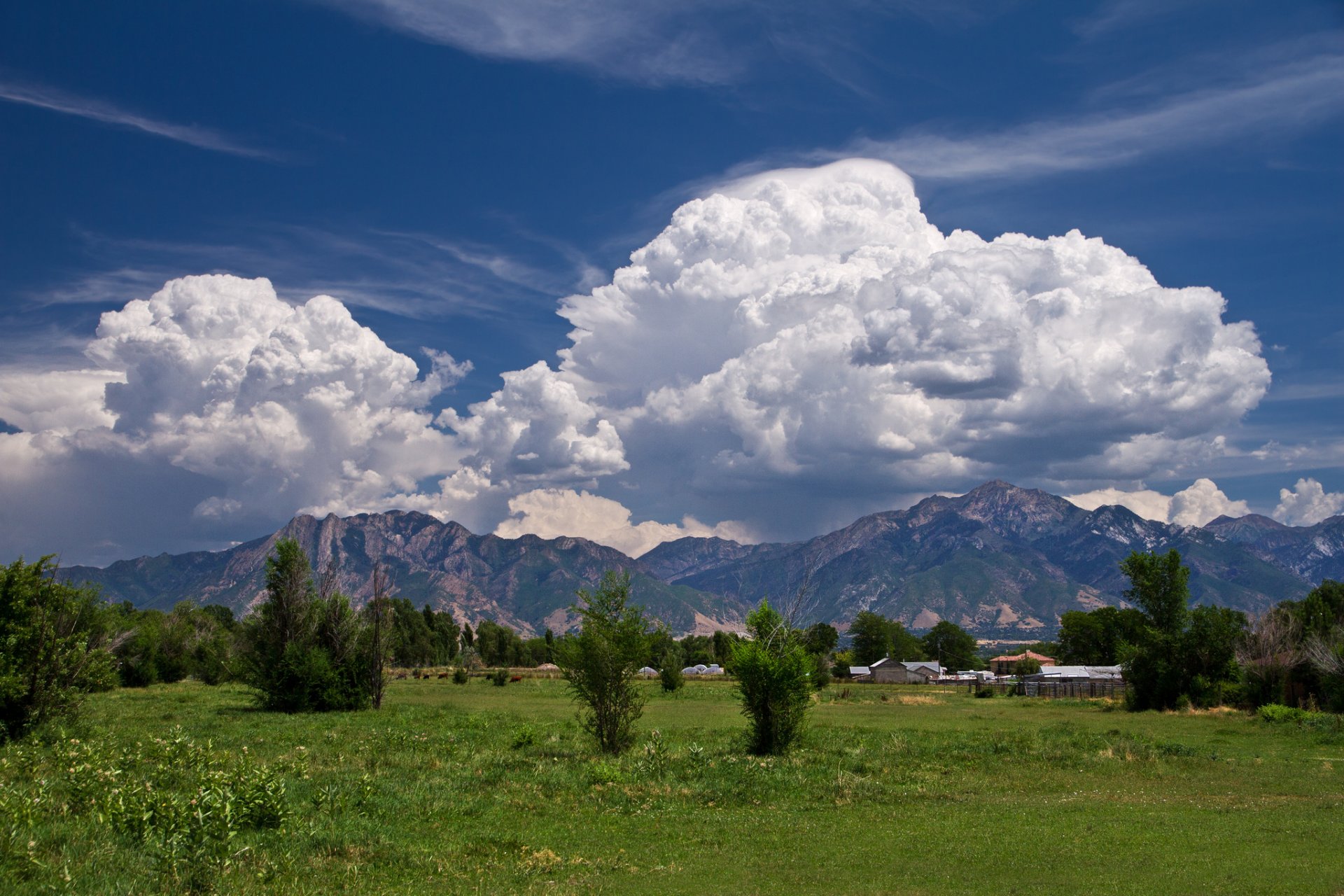 montagnes maisons prairies ciel nuages