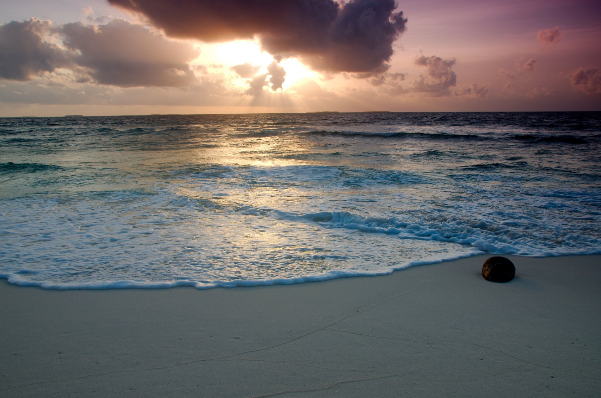 mare acqua schiuma spiaggia sabbia pietra cielo nuvole raggi del sole