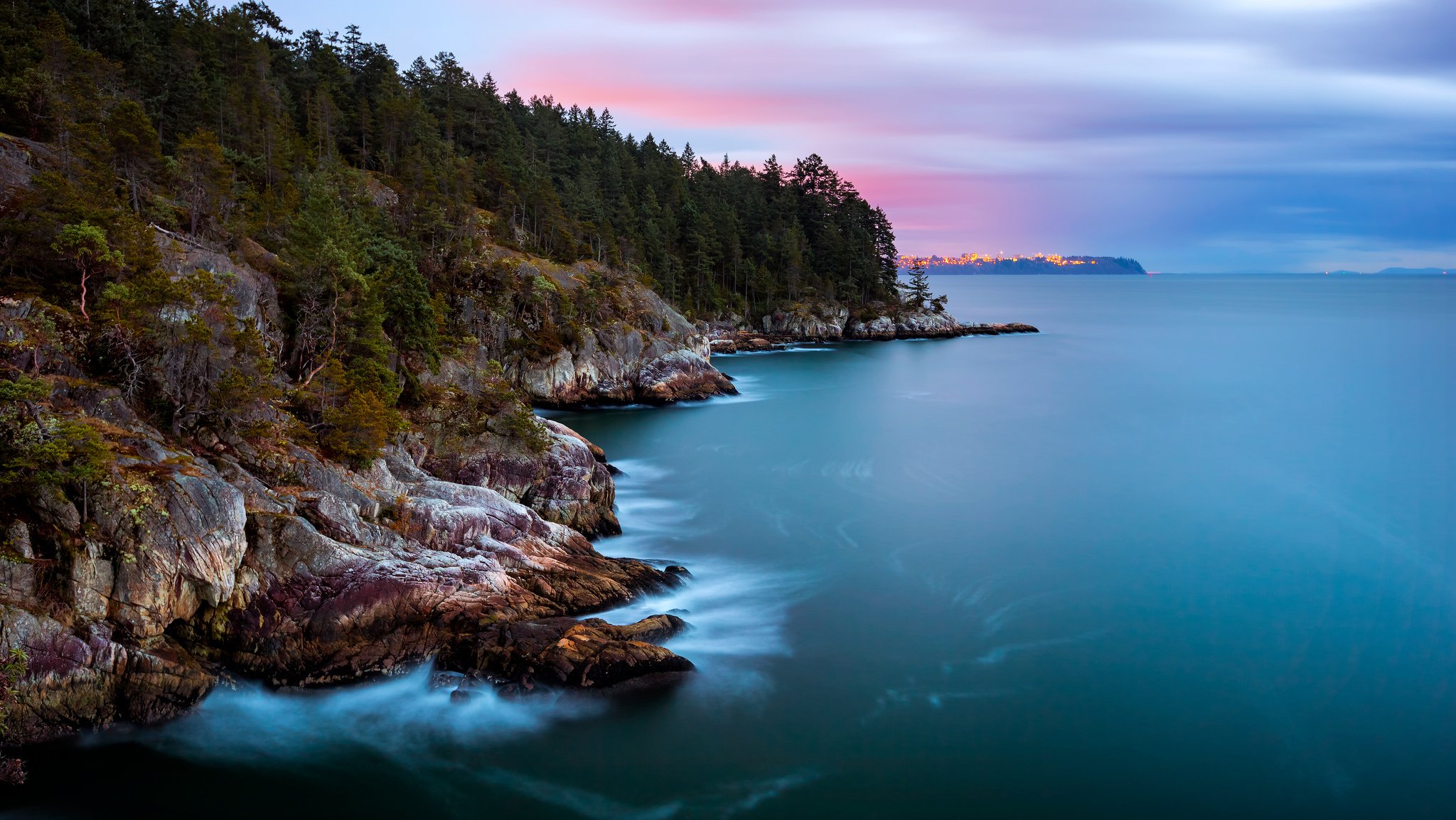 kanada british columbia provinz meerenge ozean küste insel felsen bäume wald stadt entfernt lichter abend himmel wolken