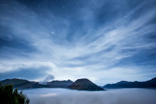 Estrellas centelleantes sobre la isla en la niebla