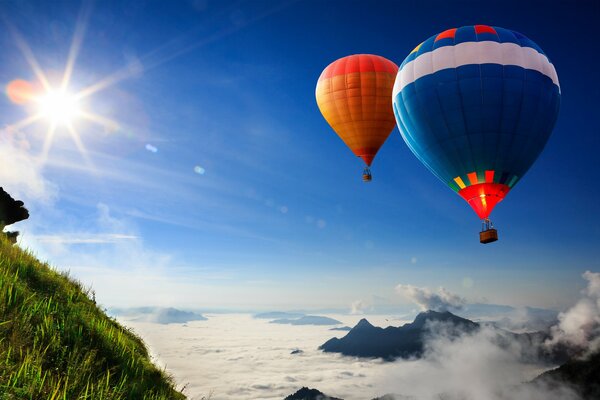 Fliegende Ballons auf dem Hintergrund des Himmels und des grünen Abhanges