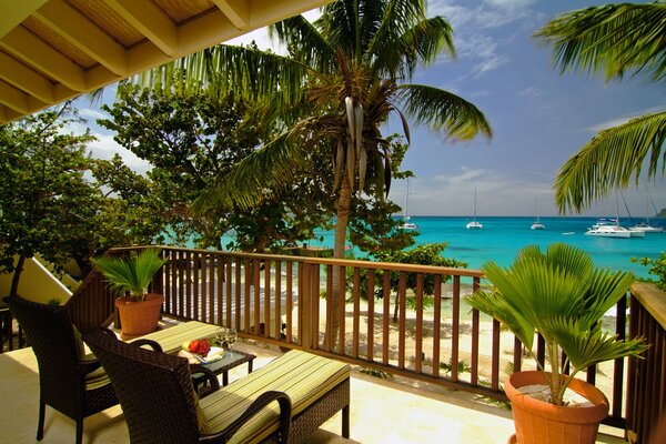 Balkon mit zwei Liegestühlen mit Blick auf das Meer und den Strand