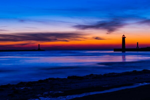 Lago con faro en Michigan en medio de una brillante puesta de sol